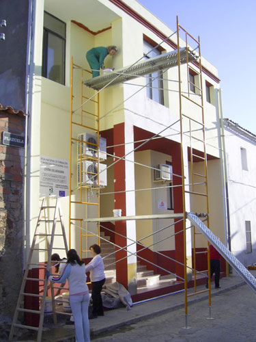 Alumnos/as del taller de pintura pintando el edificio de la Universidad Popular de Esparragosa de Lares, haga clic para ampliar la imagen