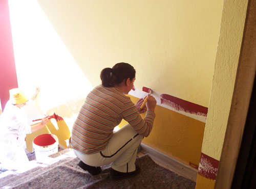 Alumnos/as del taller de pintura pintando el edificio de la Universidad Popular de Esparragosa de Lares, haga clic para ampliar la imagen