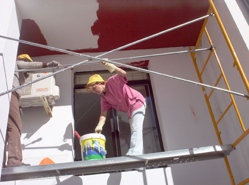 Alumnos/as del taller de pintura pintando el edificio de la Universidad Popular de Esparragosa de Lares, haga clic para ampliar la imagen