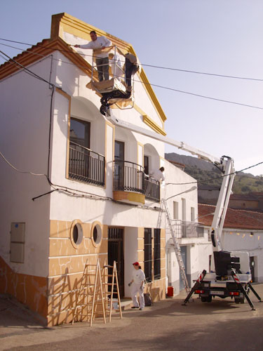 Alumnos/as del taller de pintura pintando el edificio del Ayuntamiento del Risco, haga clic para ampliar la imagen