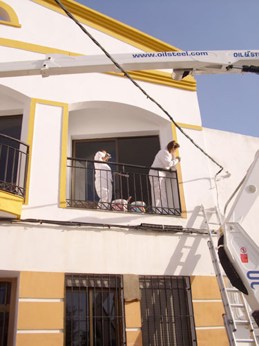 Alumnos/as del taller de pintura pintando el edificio del Ayuntamiento del Risco, haga clic para ampliar la imagen