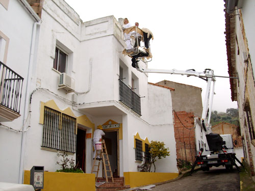 Alumnos/as del taller de pintura pintando el edificio del Ayuntamiento del Risco, haga clic para ampliar la imagen